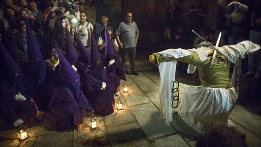 El penitente se arrodilla en señal de duelo y respeto frente a la procesión de nazarenos que recorre Valverde de la Vera esa noche, rezando una breve oración. Foto: Paco Puentes / elpais.com